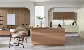 Mat gelakte fronten in warm terracotta met afgeschuinde hoeken in retrodesign ontmoeten saliegroene bovenkasten en een donkere eikenlook. Het ovale houten tafelblad sluit naadloos aan op het eiland en verbindt koken, eten en wonen tot een harmonieus geheel. Zuordnung: Stil Moderne keukens, Planungsart Keuken met keukeneiland
