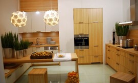 Houten keuken in U-vorm met zitgelegenheid. Fronten in licht houten tint en mat witte tint met grepen. Een onderkast loopt onder de tafel door. Zuordnung: Stil Klassieke keukens, Planungsart Detail keukenontwerp