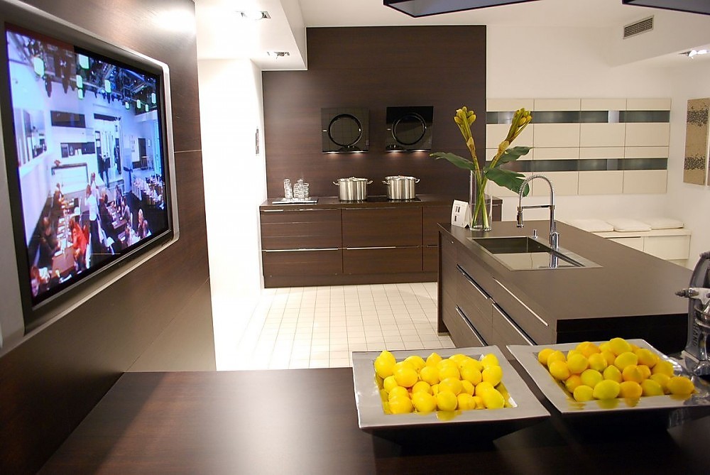 Hier ziet u een voorbeeld ervan, hoe een televisie elegant in een keuken kan worden ingebouwd. Het apparaat zit achter een wand die dezelfde tint heeft als de keukenmeubels. Zuordnung: Stil Design-keukens, Planungsart Open keuken (woonkeuken)