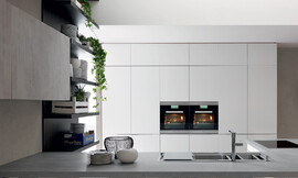 Deze greeploze keuken wordt gekenmerkt door een zeer puristische vormentaal en modern design. De kastenwand is symmetrisch en kwadratisch. Het ruime kookeiland op de voorgrond werkt puur door zijn subtiele lichtgrijstinten. Zuordnung: Stil Design-keukens, Planungsart Keuken met keukeneiland