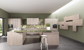 Moderne behaaglijkheid en absolute elegantie. Het oppervlakte is gebeitst in de tint &quot;zilver eik&quot;, waardoor deze top-keuken herinnert aan de natuurlijkheid van oude versleten houtplanken. Daarnaast is er in het aanrechtblad gebruik gemaakt van een mos-motief.

De keuken bestaat uit vele losse onderdelen. Twee eilanden, verbonden door het werkblad zorgen voor een zitgelegenheid en genoeg bergruimte voor potten en pannen. Het wandgedeelte bestaat aan weerszijden uit hoge kasten waarin op praktische werkhoogte de apparatuur is opgenomen. Tussen de hoge kasten zijn de onderkasten aangebracht met daarboven een legplank en nog een paar hangkasten, zodat er werkelijk genoeg bergruimte in deze ruime keuken beschikbaar is. Zuordnung: Stil Klassieke keukens, Planungsart Open keuken (woonkeuken)