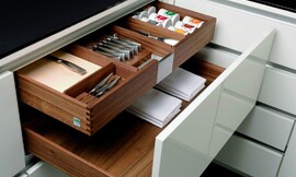 Voorbeeld van een houten bestek- en kruidenlade binnen een grotere lade. Hier uitgevoerd met hoogglans wit front. Deze combinatie biedt perfecte opslagruimte voor besteksets, kruiden en tafellakens. Zuordnung: Stil Moderne keukens, Planungsart Keuken met zitgelegenheid