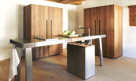 De keukenwerkplaats b2 in opgeruimde, gesloten vorm. Als de kasten dicht zijn is de keuken optisch kalm. Hier zijn de kasten uitgevoerd in mat gelakt hout. Zuordnung: Stil Design-keukens, Planungsart Keuken met keukeneiland