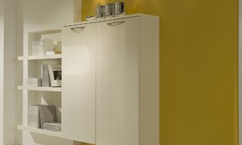Hier ziet u een hangende hoogkast tegen de achtergrond van een mango gele wand. Links is een boekenkast in de wand ingebouwd. Zuordnung: Stil Moderne keukens, Planungsart Keuken met zitgelegenheid