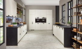 In decente landhuisoptiek presenteert zich deze twee-blokkige keuken. De donkere werkplaat wordt als zijwand verdergezet, wat de keukenblokken een attraktieve inlijsting geeft. Zuordnung: Stil Moderne keukens, Planungsart U-vormige keuken