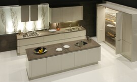 Greeploze L-keuken met riant kookeiland. Kasten met vouwdeuren voor praktische bergingsruimte. Contrast tussen glanzend lichtgrijs en een donkere, matte grijstint in het aanrechtblad. Zuordnung: Stil Moderne keukens, Planungsart Keuken met keukeneiland
