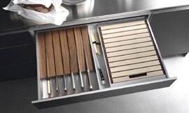Speciale lade om uw messen beschermd en uit het zicht op te bergen. Hier uitgevoerd in een keukenkastje met metallic tinten en een rvs-aanrechtblad. Zuordnung: Stil Design-keukens, Planungsart Keuken met zitgelegenheid