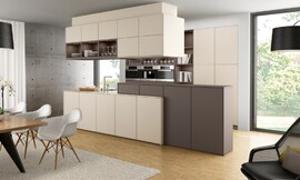 Een bijzondere mate aan wooncomfort wordt bereikt door de kleur- en materiaalkeuze en verlichting. Een warme mokkatint in combinatie met fronten in de kleur 'magnolia' benadrukt de verschillende bereiken van de keuken op speelse wijze. Zuordnung: Stil Moderne keukens, Planungsart L-vormige keuken