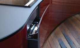 Vrijstaand, licht afgerond keukenblok met design afzuigkap. Mat grijs werkblad en hoogglans bordeauxrode fronten. Greeploze fronten. Zuordnung: Stil Design-keukens, Planungsart Detail keukenontwerp