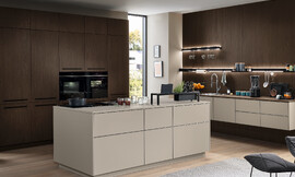 Elegante en functionele keuken met een licht, eenkleurig frontdecor, greeploos design en veelzijdige indeling met eiland en hoogwaardige uitrusting. Zuordnung: Stil Moderne keukens, Planungsart U-vormige keuken