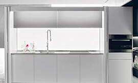 De glazen achterwand met led-verlichting maakt deze keuken tot eyecatcher. Zuordnung: Stil Design-keukens, Planungsart L-vormige keuken
