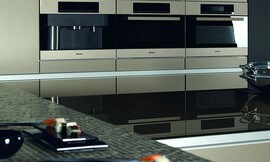 Apparaathoogkast met gember metallic fronten. Design keuken met aanrechtbladen van glas en mozaïek. Koel design met spiegelende hoogglans elementen. Zuordnung: Stil Klassieke keukens, Planungsart Detail keukenontwerp