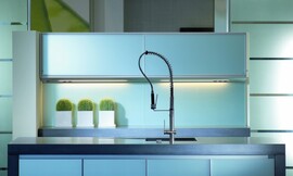 Keuken met lichtblauwe glazen fronten. Gootsteen in aanrechtblad met professionele, uittrekbare keukenmengkraan. Zuordnung: Stil Moderne keukens, Planungsart L-vormige keuken