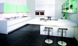 Deze hoogwaardige greeploze keuken met gesatineerd glas werkt koel en rechtlijnig. Het eerste wandelement bestaat uit vier brede onderkasten waarin grote lades zijn opgenomen. Ook de spoelbak bevindt zich in dit keukenelement. Daarboven zijn de twee opvallende brede en exotisch groene hangkasten geplaatst. Deze elegante bovenkast met schuifdeuren "Volare" is in elke breedte en verschillende hoogtes verkrijgbaar. De apparatuur is opgenomen in het volgende keukenelement met hoge kasten. Tot slot is er het ruime kookeiland met zitgelegenheid aan de andere kant en open kasten aan de muur met dezelfde opvallend groene tint als de bovenkasten daar tegenover. Dit open kastsysteem, Varietas, is ook in verschillende formaten verkrijgbaar. Zuordnung: Stil Design-keukens, Planungsart Keuken met keukeneiland