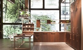Kalme houten keuken met licht en dun aanrechtblad en deels kasten die open en dus doorzichtig zijn. Robuuste grepen. Een lagere tafel met zitgelegenheid. U-vorm. Contrast tussen mooi donker hout en lichte werkbladen/kast. Zuordnung: Stil Klassieke keukens, Planungsart keukenblok