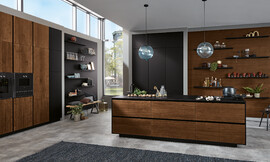Ervaar de tijdloze elegantie van deze greeploze designkeuken met donker houten fronten. Het eilandplanningstype biedt zowel een unieke uitstraling als praktische werkruimte. Zuordnung: Stil Design-keukens, Planungsart Keuken met keukeneiland